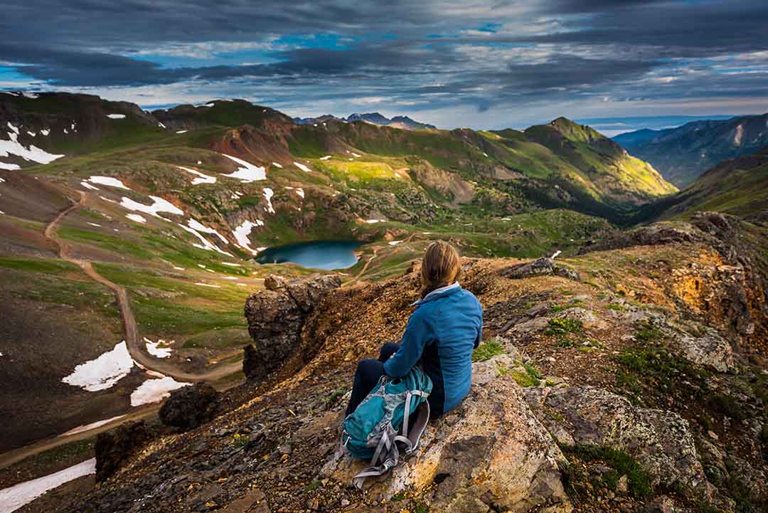 a lone woman looks out over a vast landscape