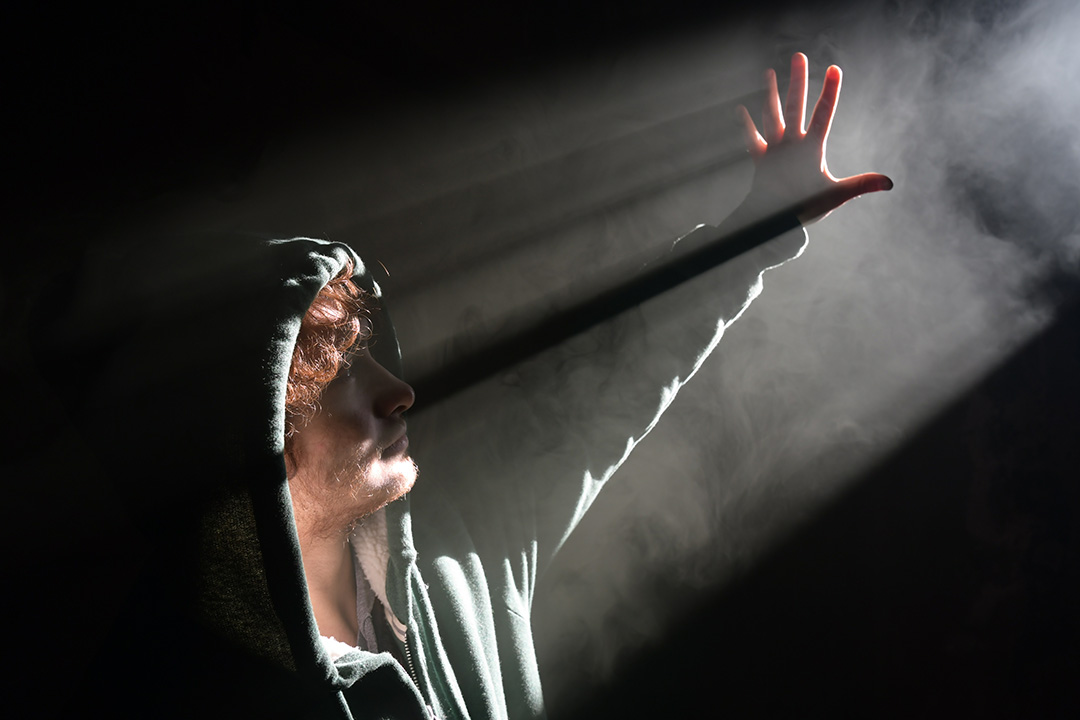 man standing in the dark, shielding himself from light